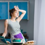 Woman experiencing holiday back pain from cooking and stress